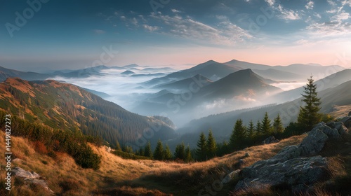 A scenic view of mountain ranges covered in fog with trees and grass in the foreground view