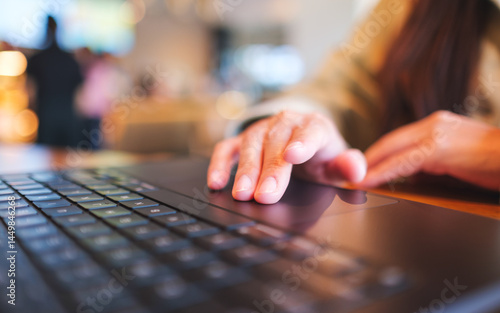 Closeup image of a woman hands working and touching on laptop computer touchpad