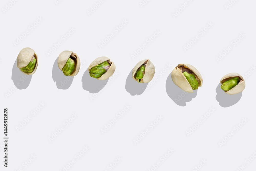 Pistachio nuts isolated on white background. Top view. Roasted green pistachios in open shells on white background with shadow.