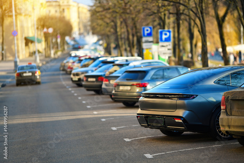 Obraz na płótnie Parked cars, dense row of parked vehicles in angle position highlights the struggle of finding space in crowded urban downtown parking lot near public parks. w salonie