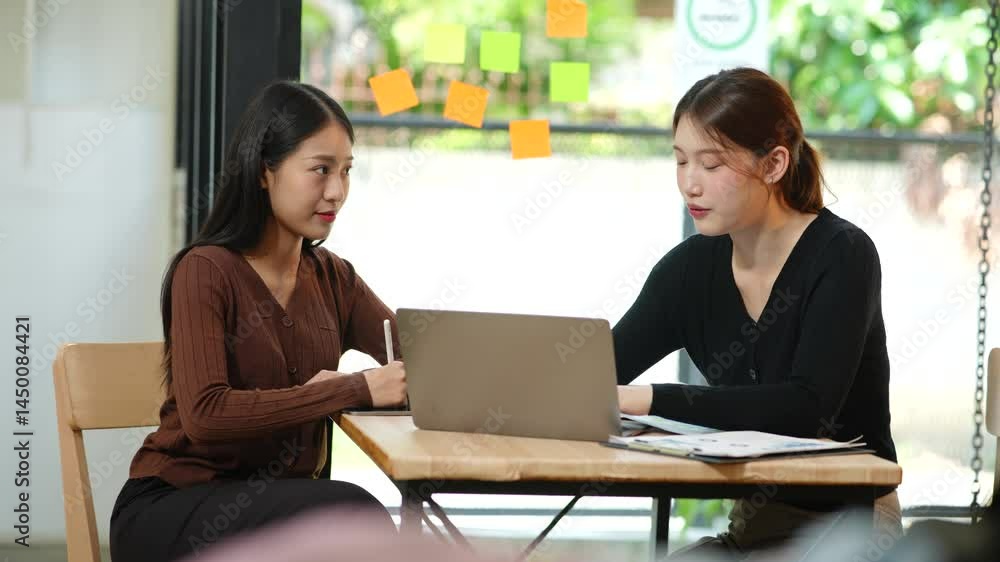 Group of Asian businesswomen working on documents in an office. Group of Asian businesswomen working on documents in an office.