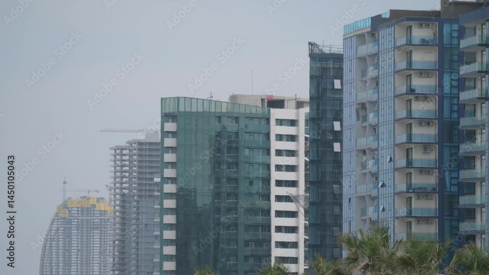 Modern high-rise buildings in Batumi, Georgia with heat haze effect in warm weather. Urban architecture, real estate development, climate. Modern high-rise buildings in Batumi, Georgia with heat haze effect in warm weather. Urban architecture, real estate development, climate.