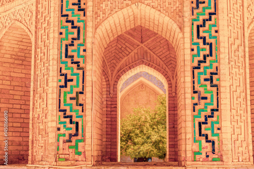 A brick archway with green and blue tiles