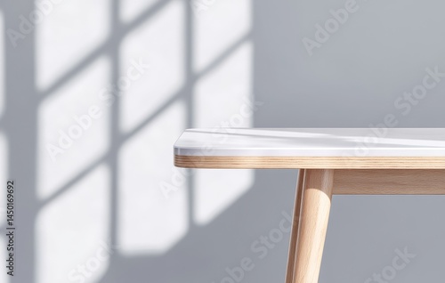 Modern Wooden Table with White Top Against a Wall with Window Shadows
