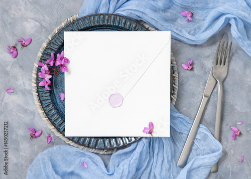 Obraz na płótnie Wedding table place with an envelope near fabric and wild purple flowers top view on gray, mockup w salonie