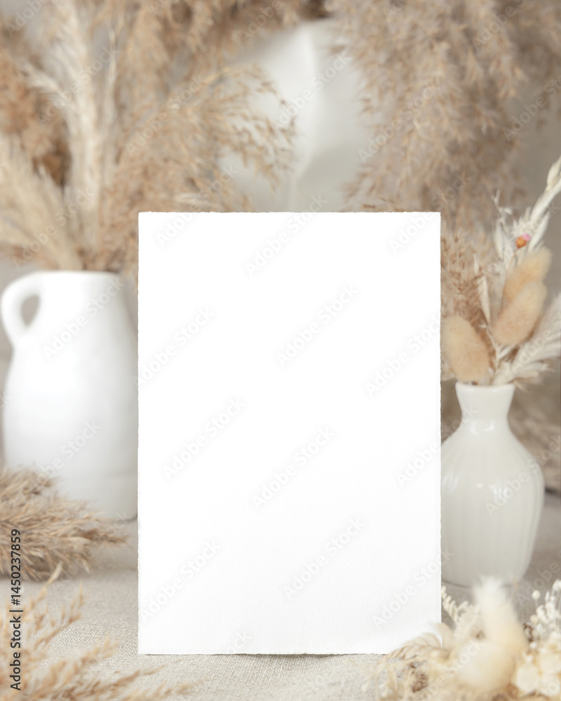 Blank card near dry beige pampas grass on linen closeup, mockup. Bohemian wedding stationery