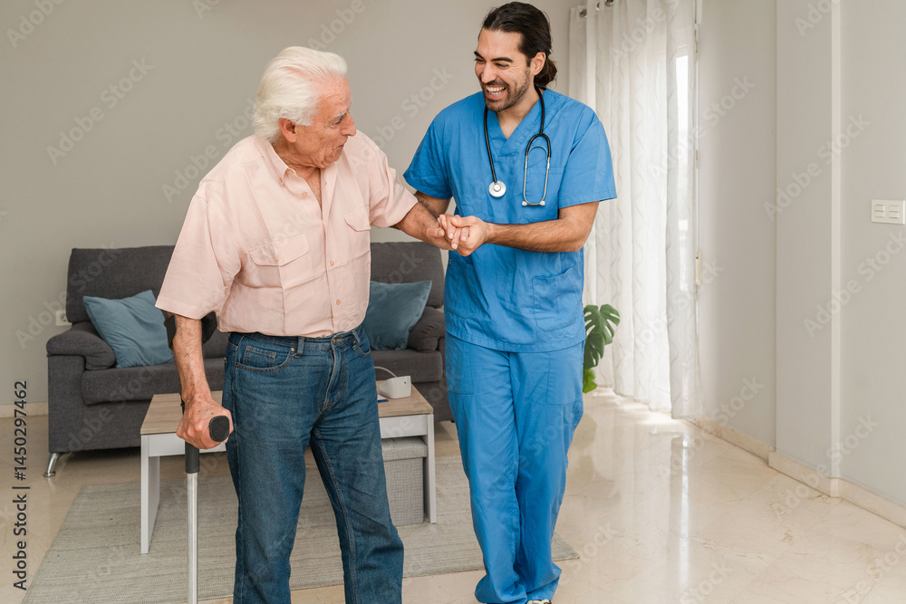 Fototapeta premium Smiling physiotherapist helping senior man walking using crutch during rehabilitation at home