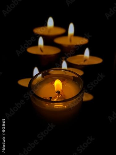 The central candle is sharply focused, surrounded by six warm, glowing candles creating a cozy and calm atmosphere
