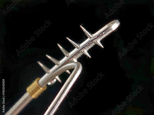Obraz na płótnie A silver and gold object with a pointed end. The object is long and thin, and it is a tool or a weapon. The image has a dark and moody atmosphere w salonie