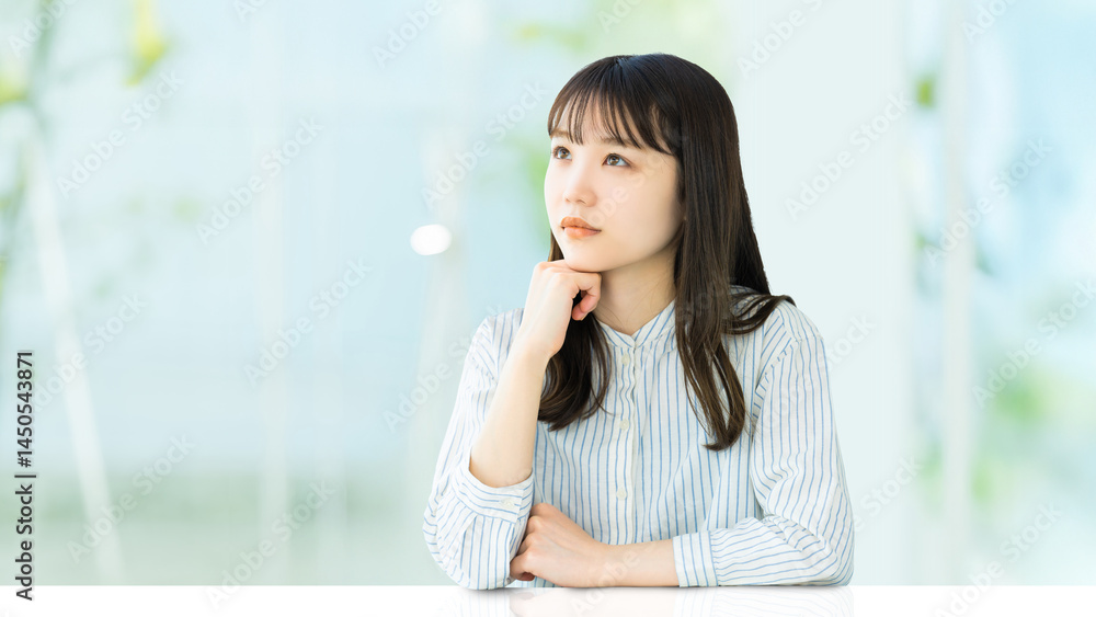 肘をついて考えごとをする女性 肘をついて考えごとをする女性