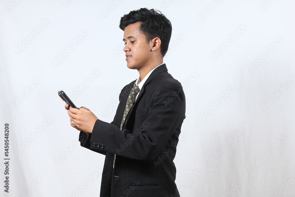 Asian man wearing black suit office worker holding smartphone sending negotiation message to client, isolated on white background.business and technology concept Asian man wearing black suit office worker holding smartphone sending negotiation message to client, isolated on white background.business and technology concept