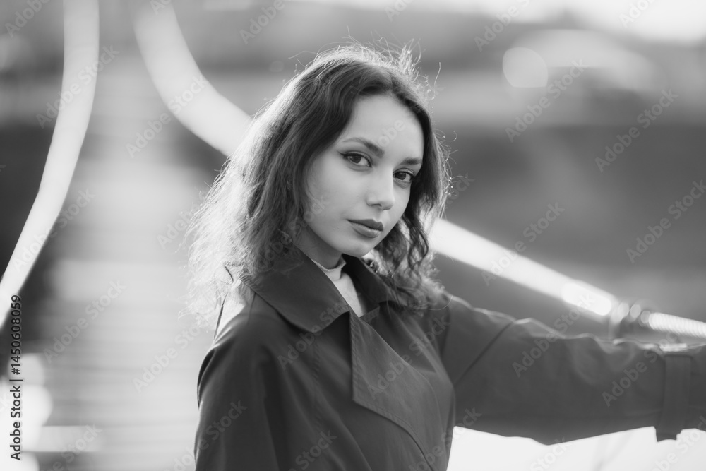 beautiful brunette european girl in blue trench coat at nature. Young lady with beautiful face and lips.