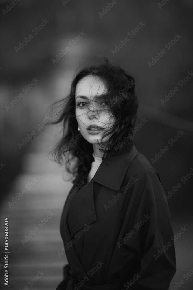 beautiful brunette european girl in blue trench coat at nature. Young lady with beautiful face and lips.