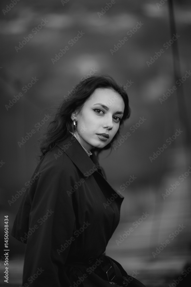 beautiful brunette european girl in blue trench coat at nature. Young lady with beautiful face and lips.
