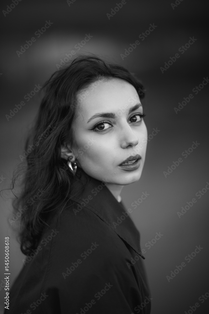 beautiful brunette european girl in blue trench coat at nature. Young lady with beautiful face and lips.