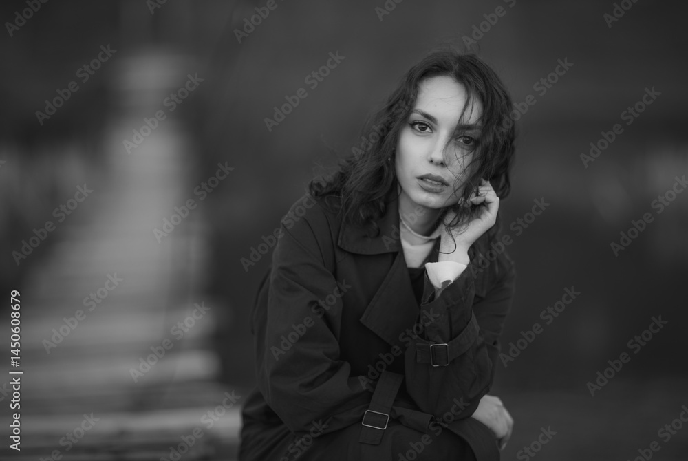 beautiful brunette european girl in blue trench coat at nature. Young lady with beautiful face and lips.