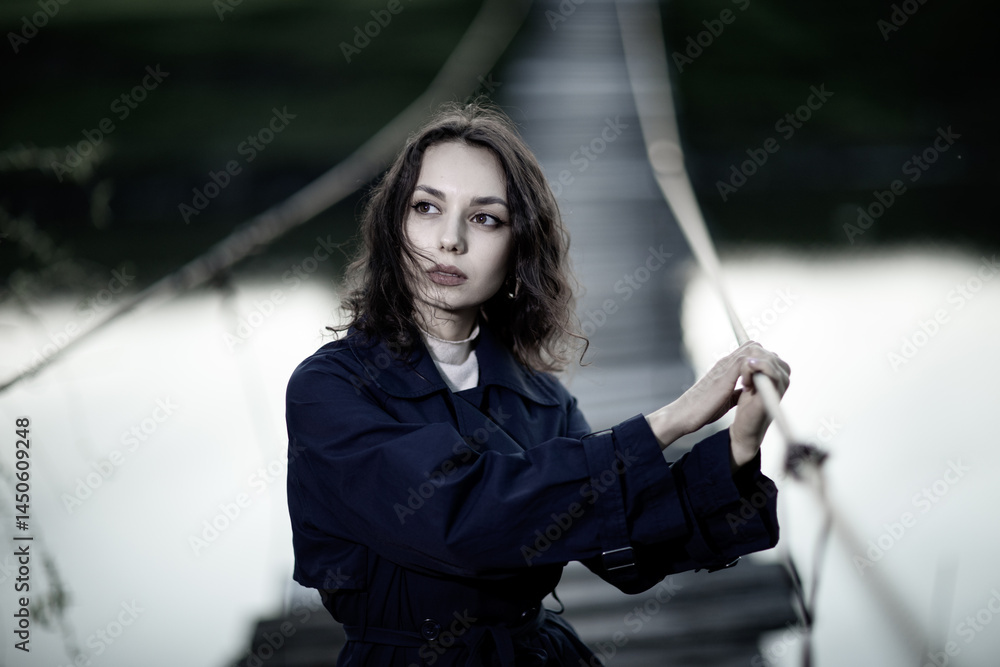 beautiful brunette european girl in blue trench coat at nature. Young lady with beautiful face and lips.