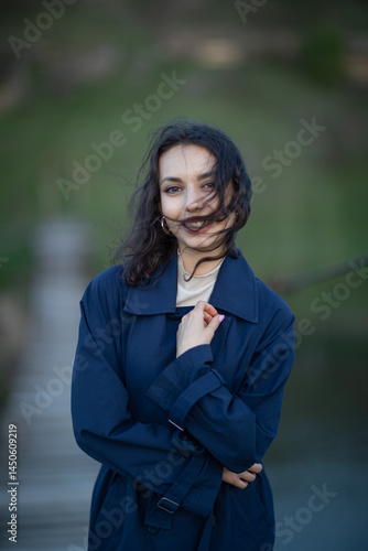 Obraz na płótnie beautiful brunette european girl in blue trench coat at nature. Young lady with beautiful face and lips. w salonie