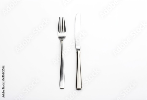 A knife, fork and spoon on a white surface.