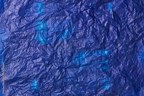 crumpled used blue carbon paper surface background, navy blue tone waxy or oily wrinkled thin sheet in full frame, textured backdrop of copy space