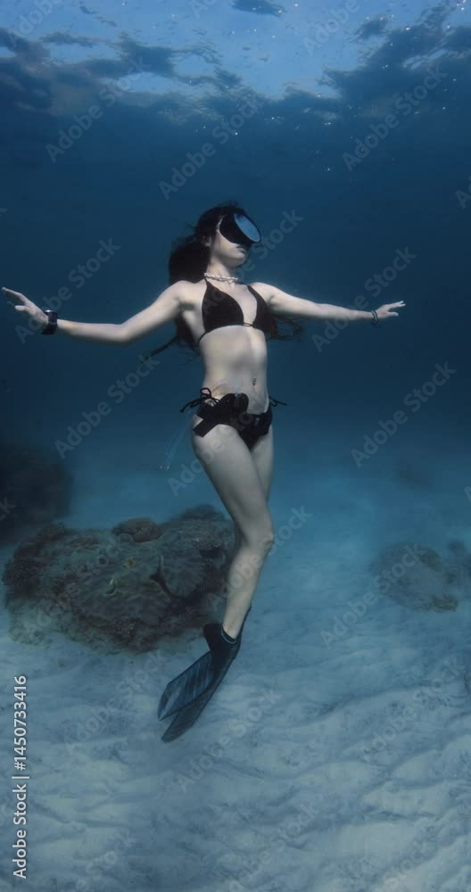 Attractive woman posing underwater in blue ocean. Sexy diver girl freediving in sea Attractive woman posing underwater in blue ocean. Sexy diver girl freediving in sea