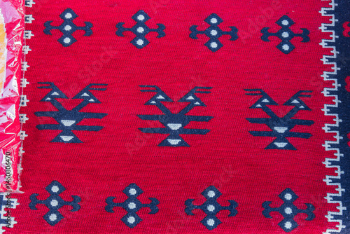 Obraz na płótnie Geometric pattern in a brightly colored red woven rug. w salonie