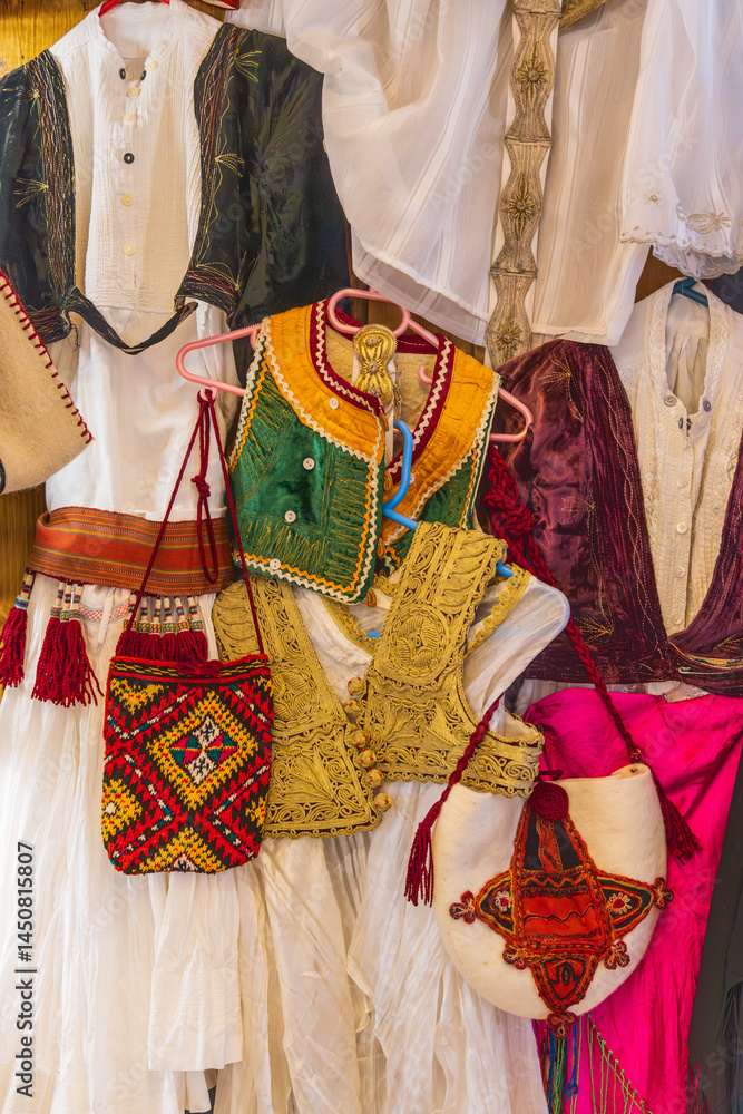 Traditional women's dresses for sale at an outdoor market in Kruje.