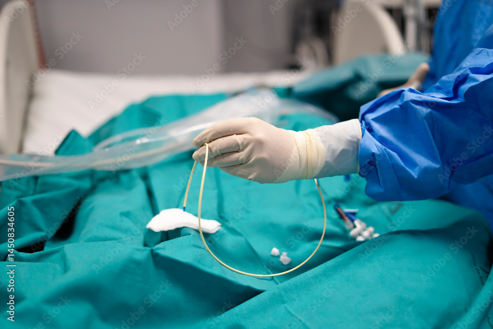 Surgeon holding a catheter during medical procedure in operating room Surgeon holding a catheter during medical procedure in operating room
