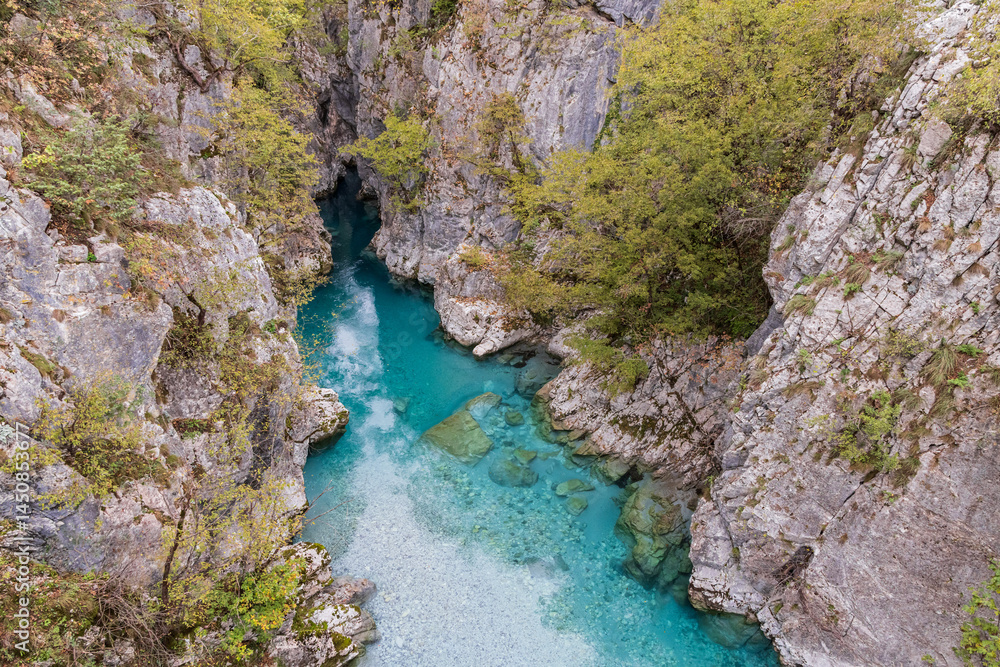 Clear aque blue water of the Valbonas River in a rocky canyon.