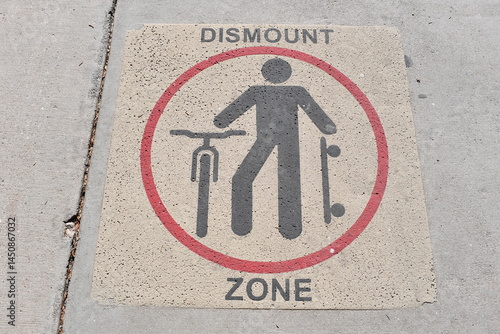 Dismount Zone. Sign painted on sidewalk. Please dismount your skateboard and bike. Busy pedestrian area.