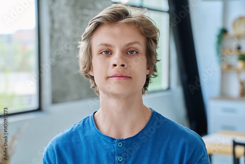Headshot portrait of serious teenage boy looking at camera