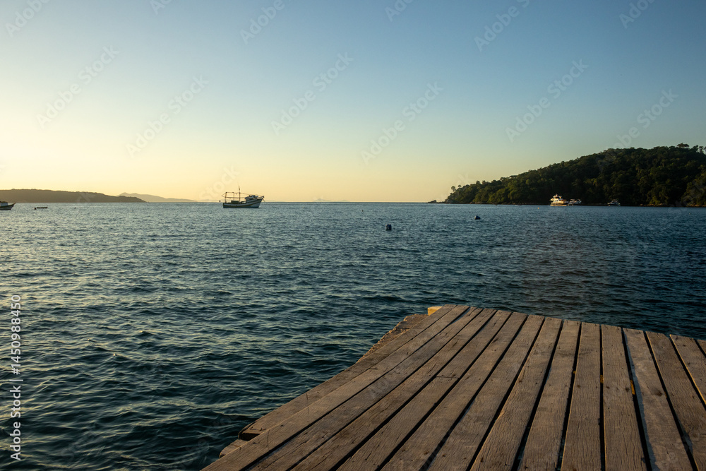 Fototapeta premium Golden Coastline Sunset – Boats, Nature and Ocean Calm