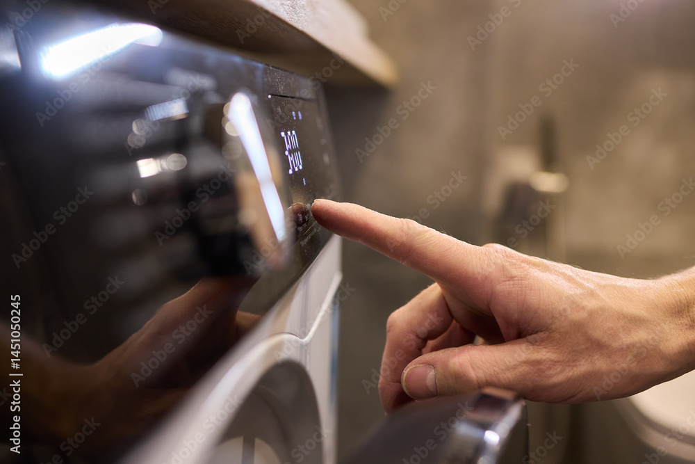 Individual Interacting with a Modern Washing Machines Control Panel for Efficient Laundry Tasks