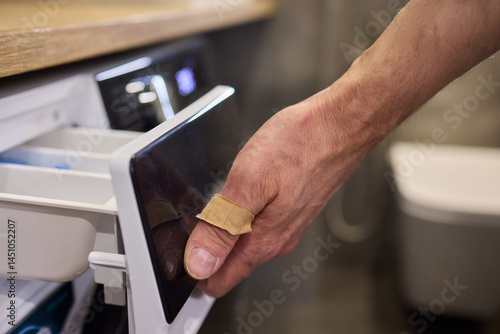 A person is effortlessly using their hand to open the drawer of a contemporary modern refrigerator