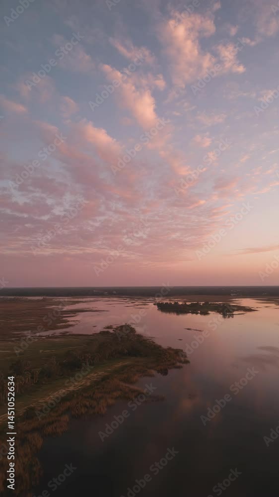 Scenic aerial landscape of marshland and water reflecting colorful sunrise sky Scenic aerial landscape of marshland and water reflecting colorful sunrise sky