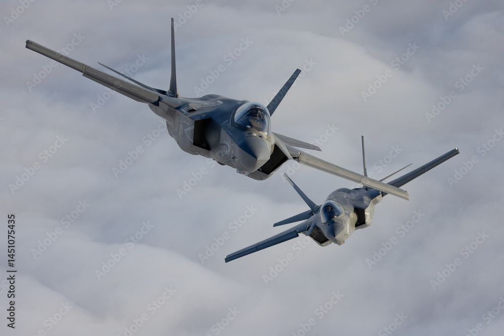 Fototapeta premium Very close top view of a pair of F-35C Lightning II over clouds
