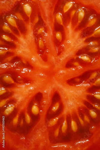 Obraz na płótnie Fresh tomato slice closeup with vibrant red texture and seeds pattern
w salonie