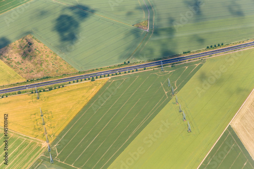 Obraz na płótnie areal of beautiful landscape near Paris with green fields,street and electric pylons for renewable energy w salonie
