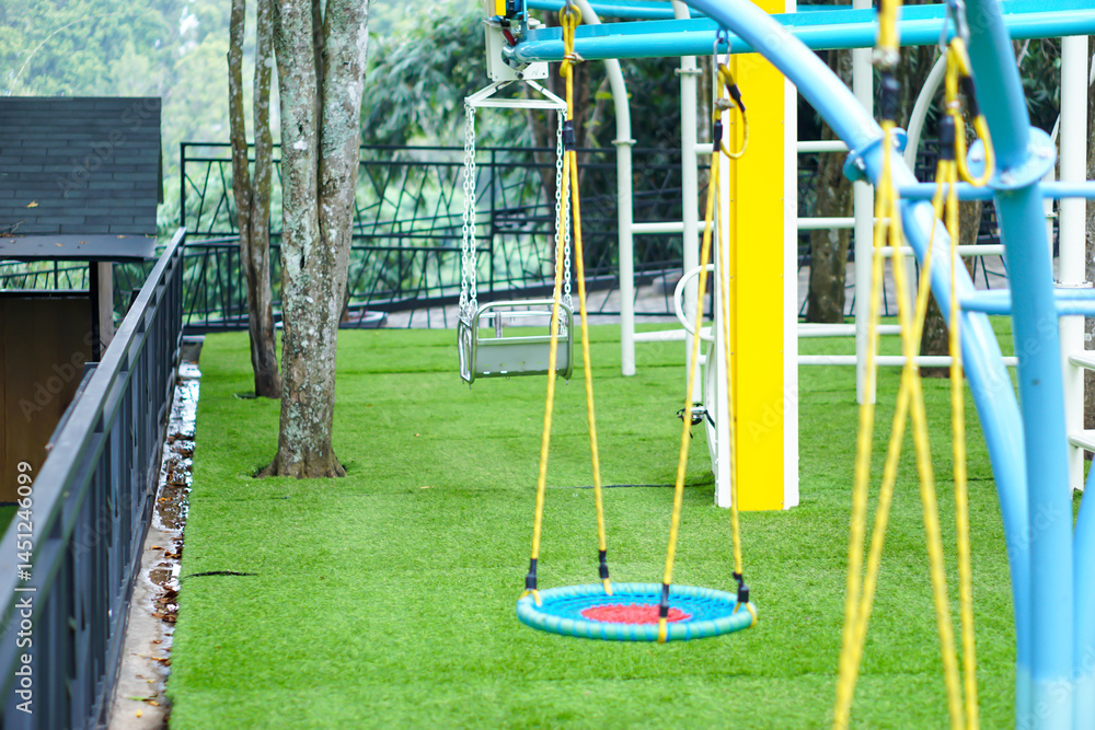 Colorful playground with swings, trees, and soft artificial grass in a fun and safe outdoor space. Colorful playground with swings, trees, and soft artificial grass in a fun and safe outdoor space.