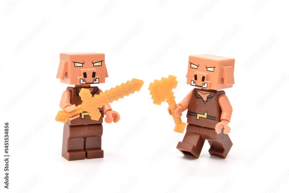 Fototapeta premium Lego minifigures of angry pigs from video game Minecraft movie are fighting with weapons or swords. Editorial illustrative image of popular plastic toys.