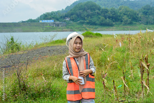 Wallpaper Mural A modern corn farm manager woman carrying a book wearing a safety vest and safety helmet. Torontodigital.ca