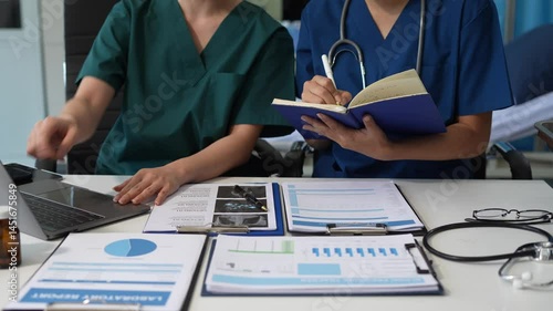 Medical team working with a tablet and Laptop computer search for medical information at the hospital office.