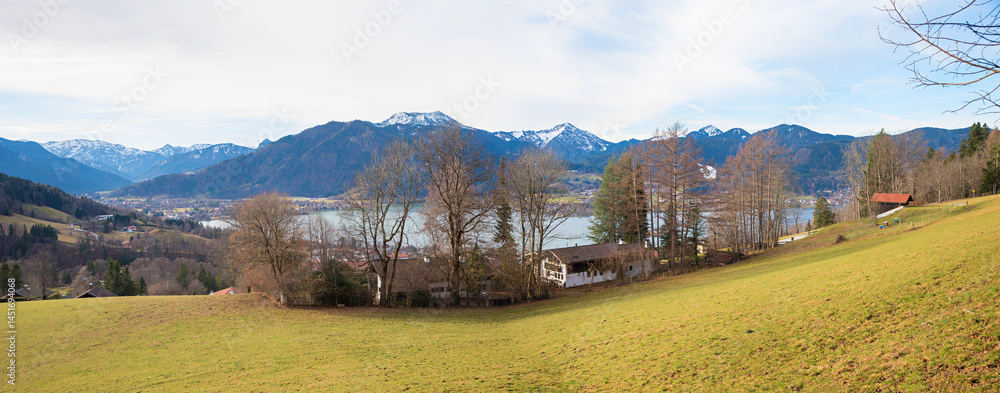 view over a meadow to lake Tegernsee and bavarian alps, early springtime upper bavaria