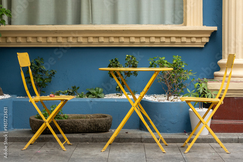 Obraz na płótnie Vibrant yellow color chairs and table at the street w salonie