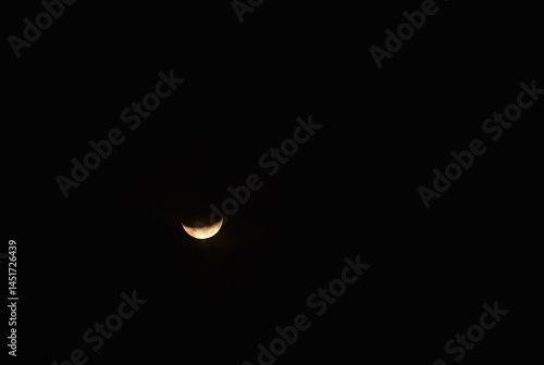 yellow half moon covering by cloud floating on sky in night background