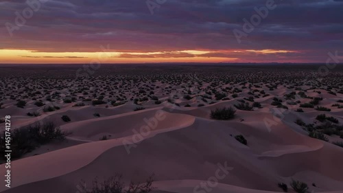 Stunning desert sunrise over rolling dunes captures dramatic sky transformation
