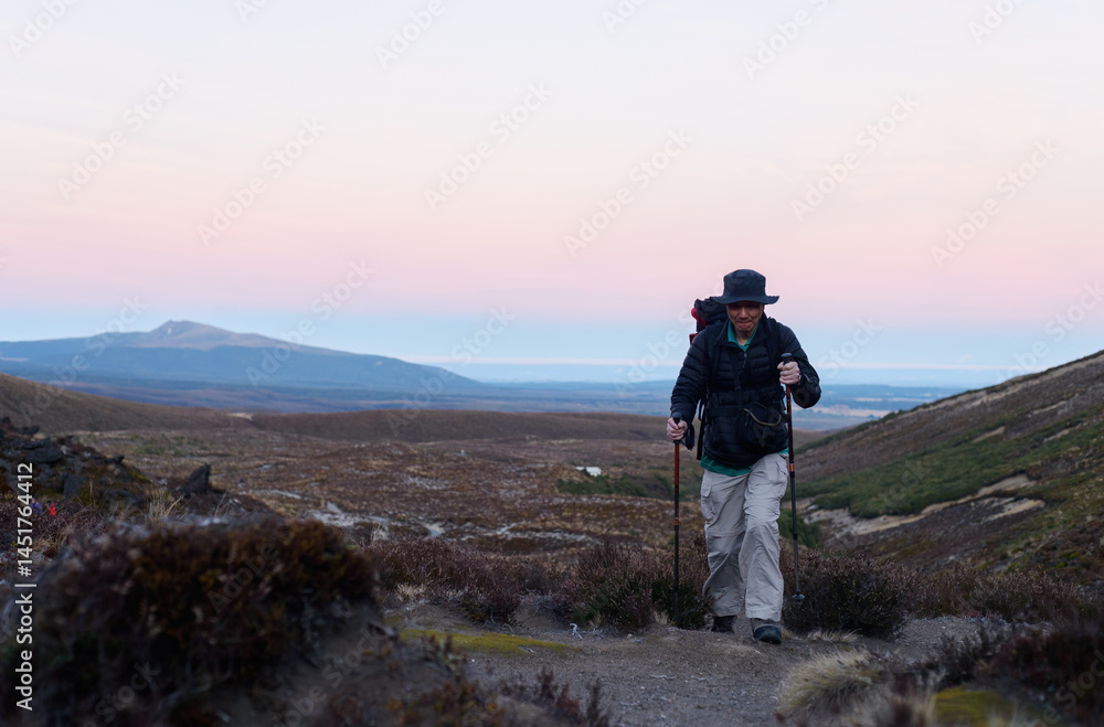 Man hiking Tongariro Alpine crossing at sunrise. Tongariro National Park. New Zealand.