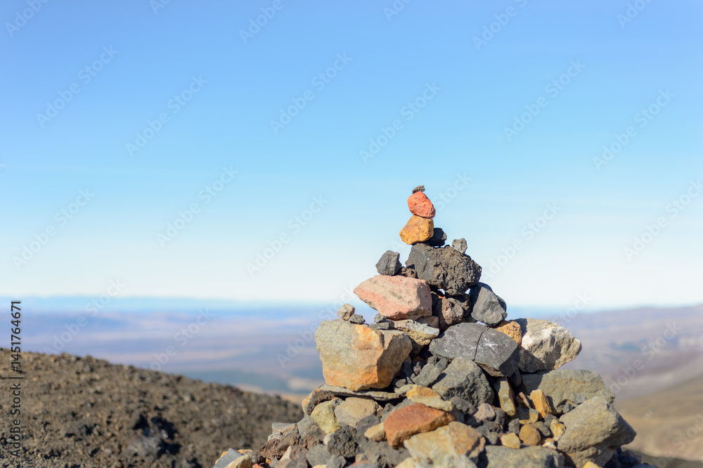 Stone stack with red rock on top at Tongariro Alpine Crossing. Tongariro National Park. New Zealand.