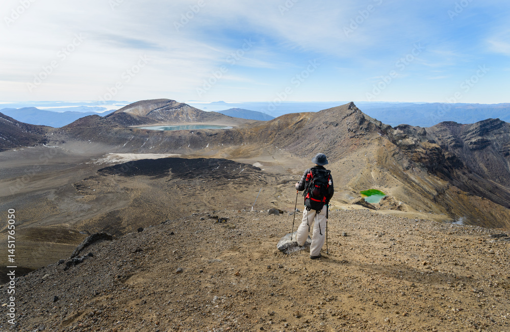 Man looking at the views of Emerald lakes and Blue Lake. Tongariro Alpine crossing, Tongariro National Park. New Zealand.