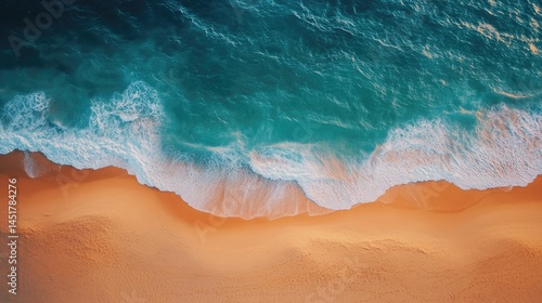 Fototapeta Naklejka Na Ścianę i Meble -  Aerial view of a sandy beach meeting turquoise ocean waves.